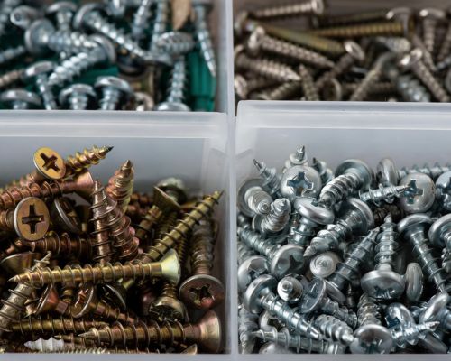 Assorted metal screws in storage boxes, featuring Phillips & Pozidriv drive heads, ideal for hardware supply, fastener manufacturing & construction projects.